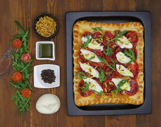 COCA CAPRESSE CON PIÑONES, RÚCULA Y ACEITE VERDE